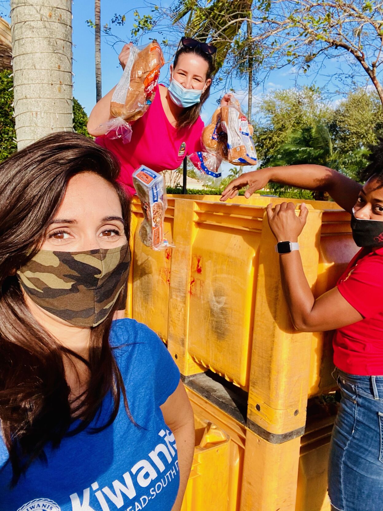 Homestead Councilwoman Erica G. Ávila (top) helps Kiwanis volunteers get ready for the annual drive-through food distribution to feed 500 families.